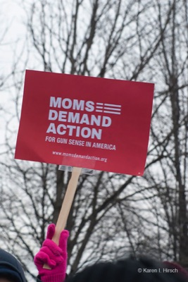 Hand holding sign Moms Demand Action